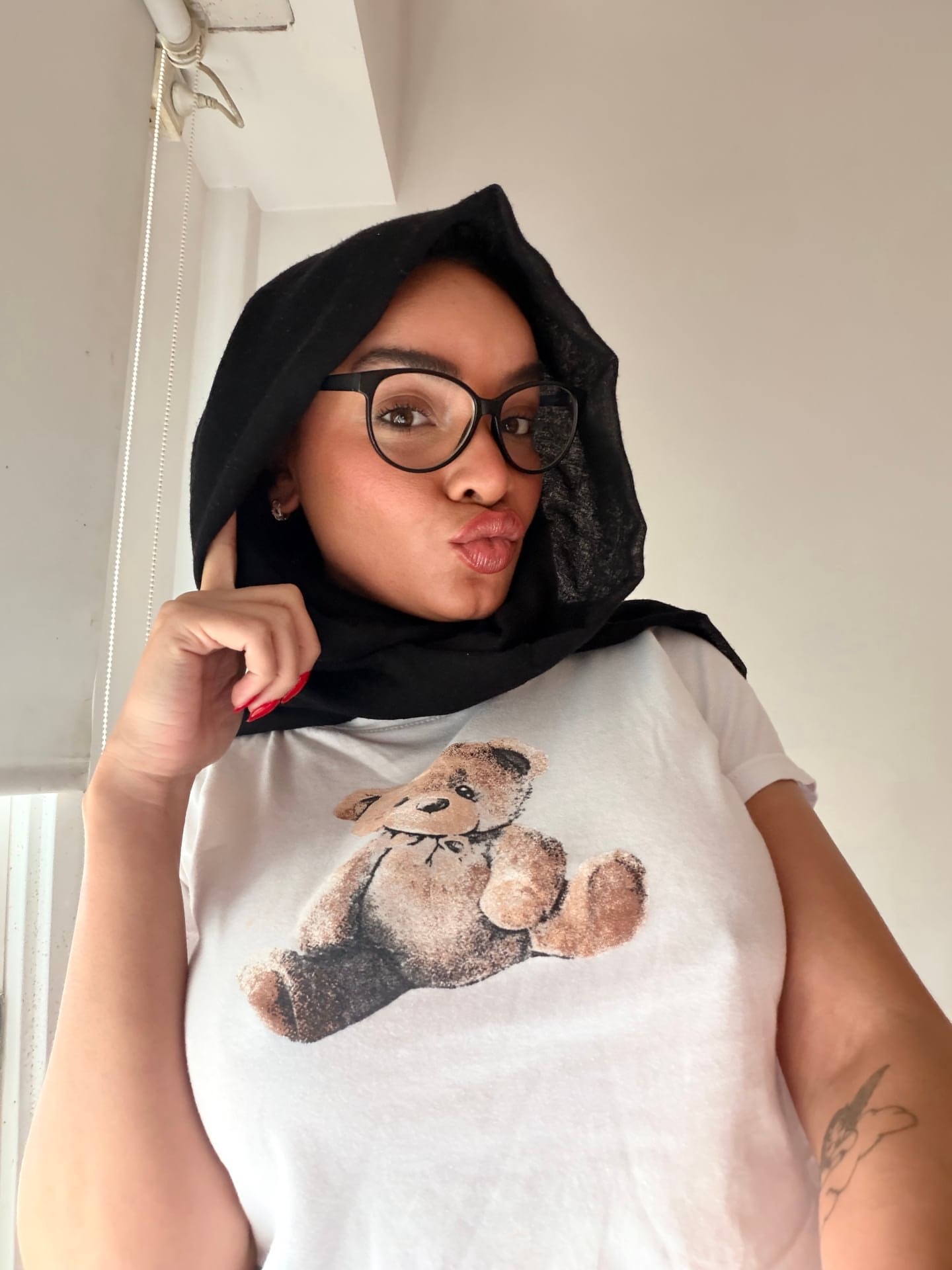 Ein Mädchen macht „SFW“-Selfies, während sie einen Hidschab und eine Brille trägt