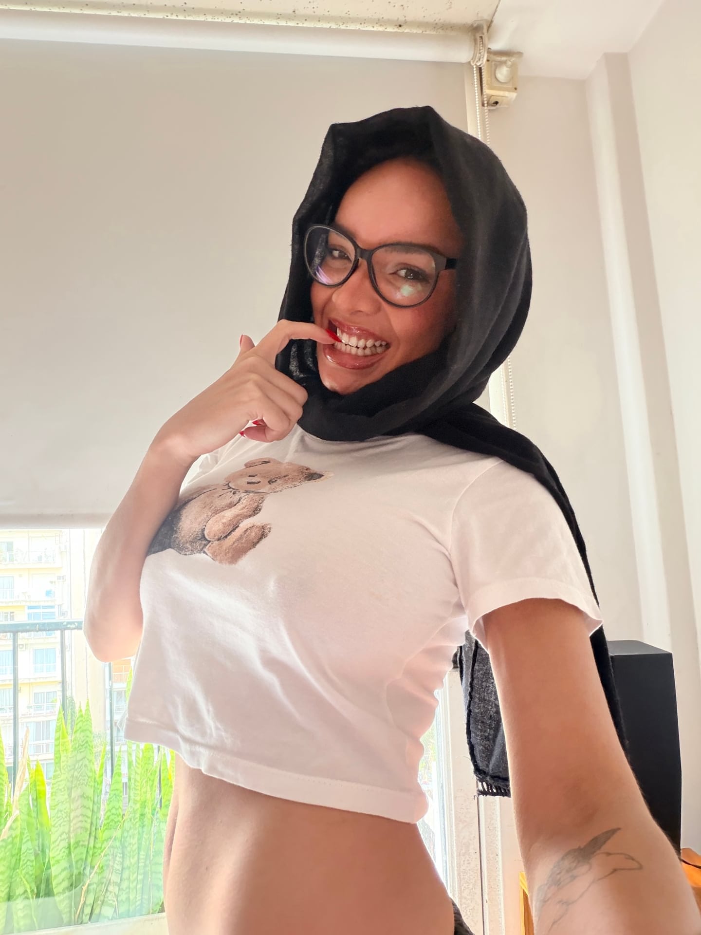 Ein Mädchen macht „SFW“-Selfies, während sie einen Hidschab und eine Brille trägt