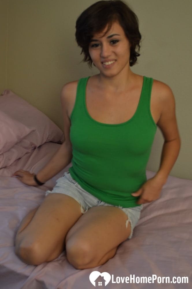 Eine sexy Amateurin zeigt ihre gebräunten Brüste und verwöhnt ihre rasierte Muschi mit einem Dildo