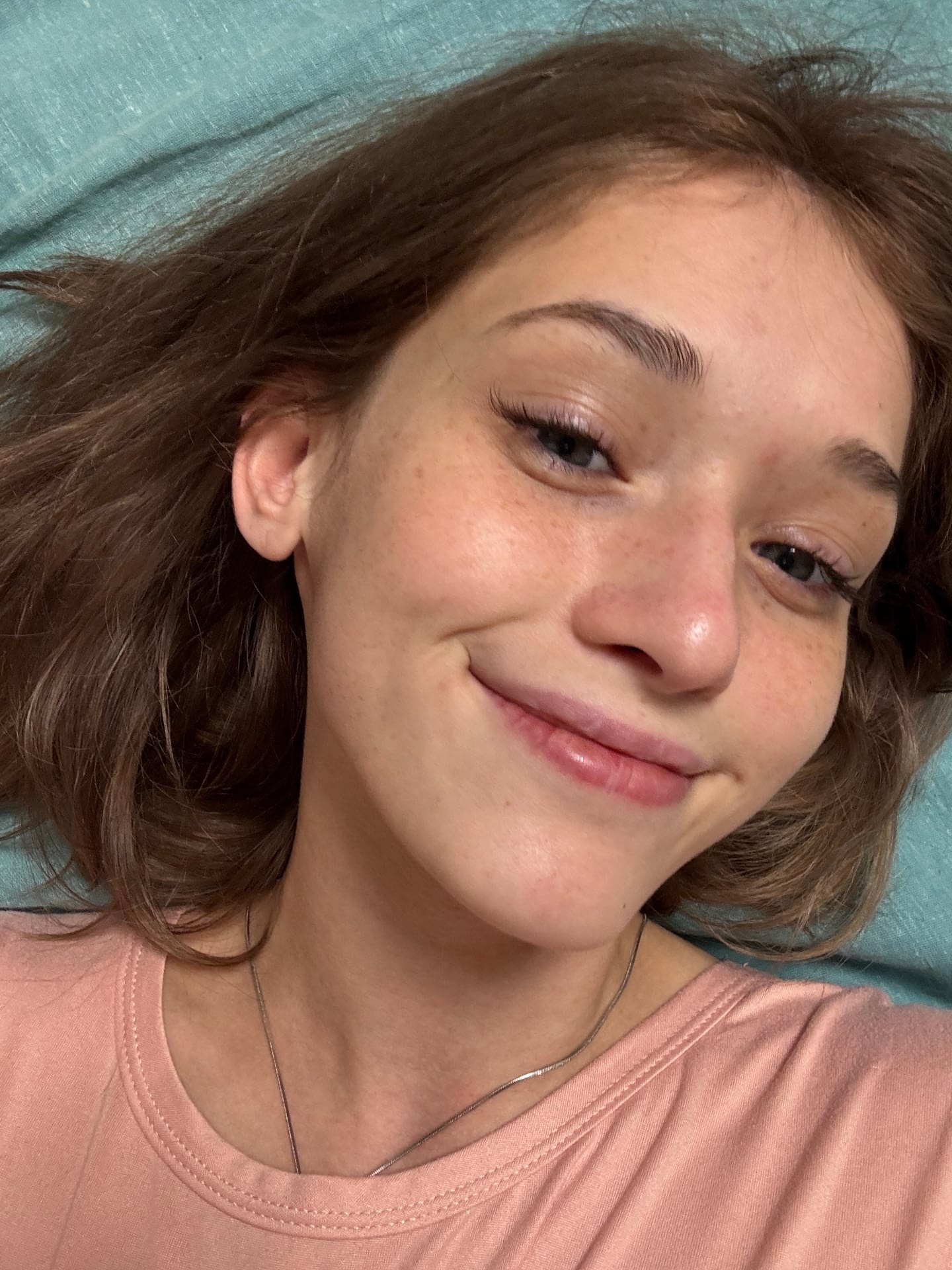 Ein Mädchen mit heller Haut und Sommersprossen zeigt sich im Freien mit ihren Tattoos