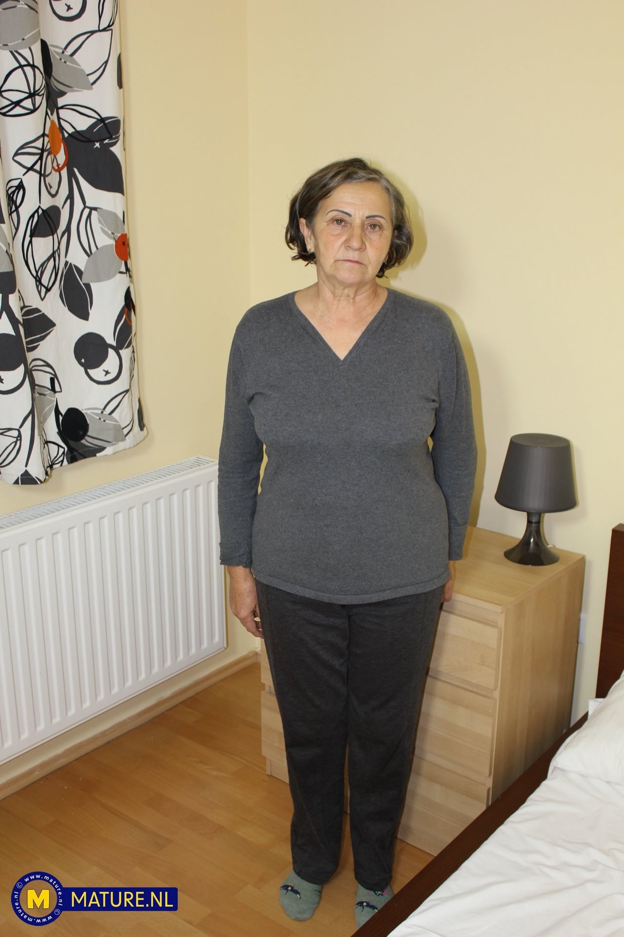 Oma Jana W zieht sich komplett aus und zeigt ihre behaarte Muschi auf einem Bett