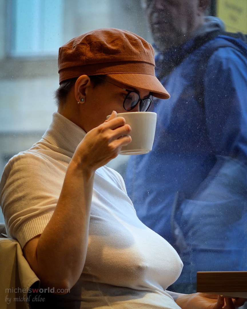 Ein Amateur-Mädchen zeigt in der Öffentlichkeit mit Mütze und Brille ihre großen Brüste