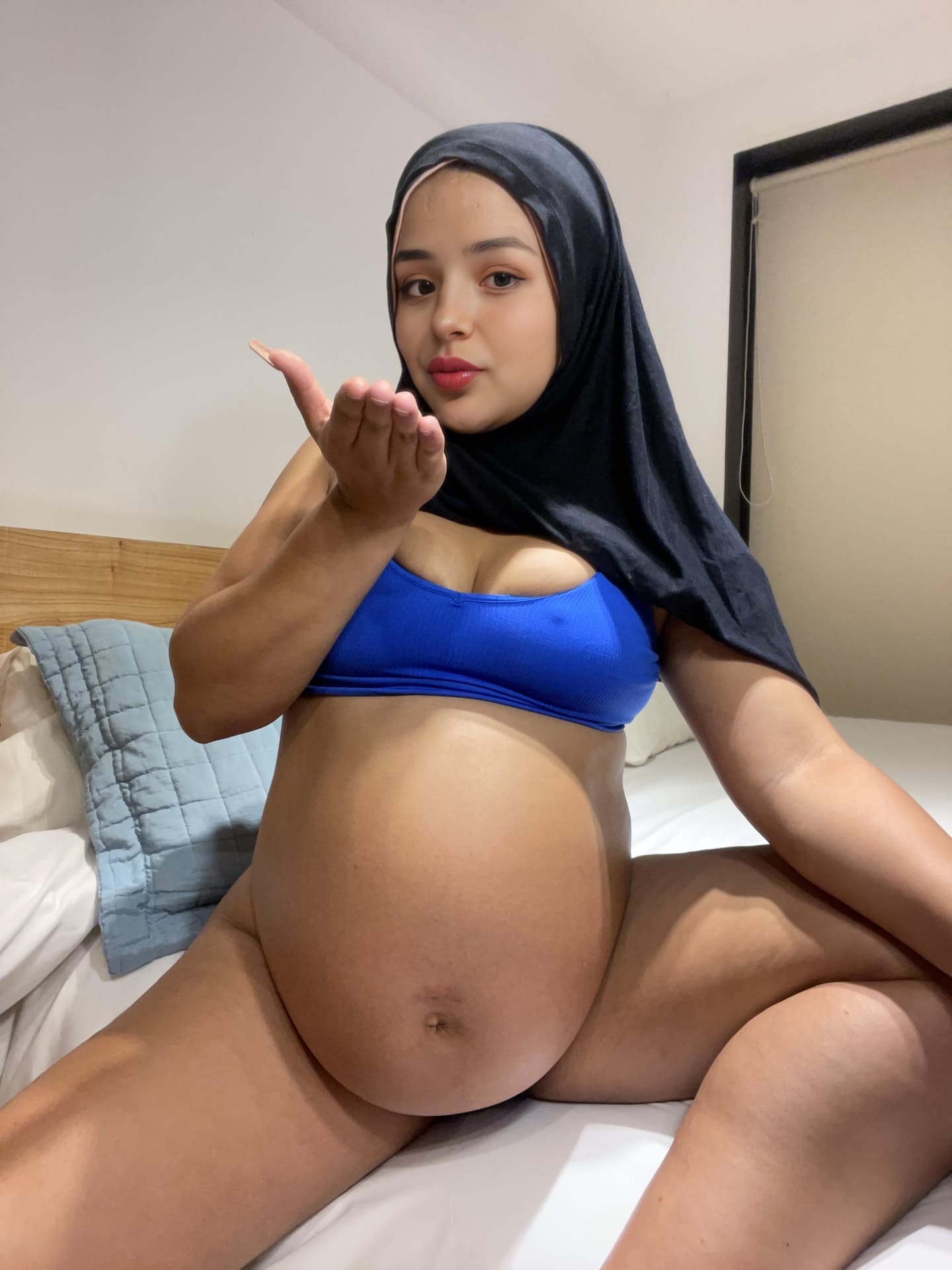 Ein Model aus dem Nahen Osten zeigt ihren riesigen Bauch, während sie einen schwarzen Niqab trägt
