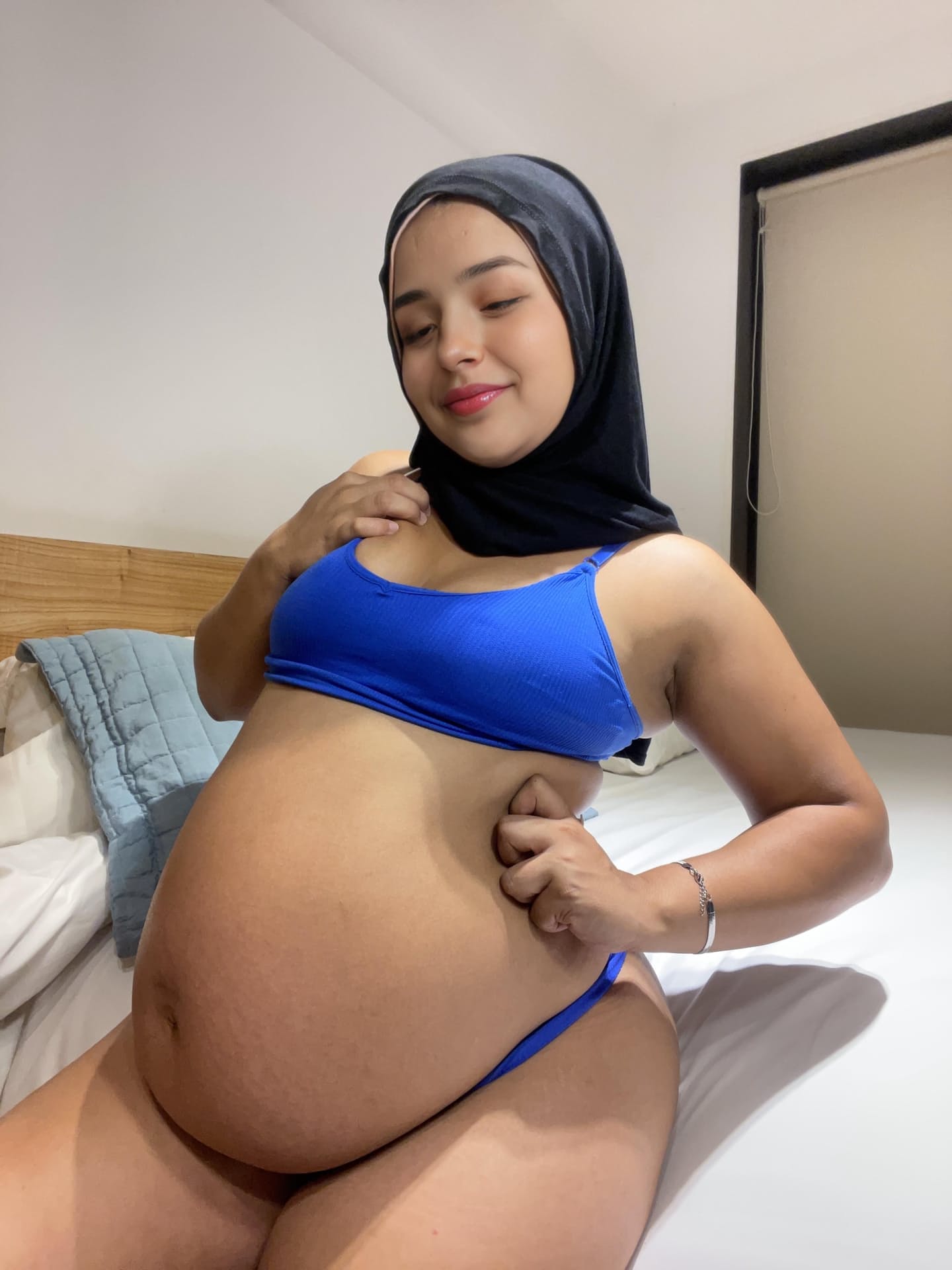 Ein Model aus dem Nahen Osten zeigt ihren riesigen Bauch, während sie einen schwarzen Niqab trägt
