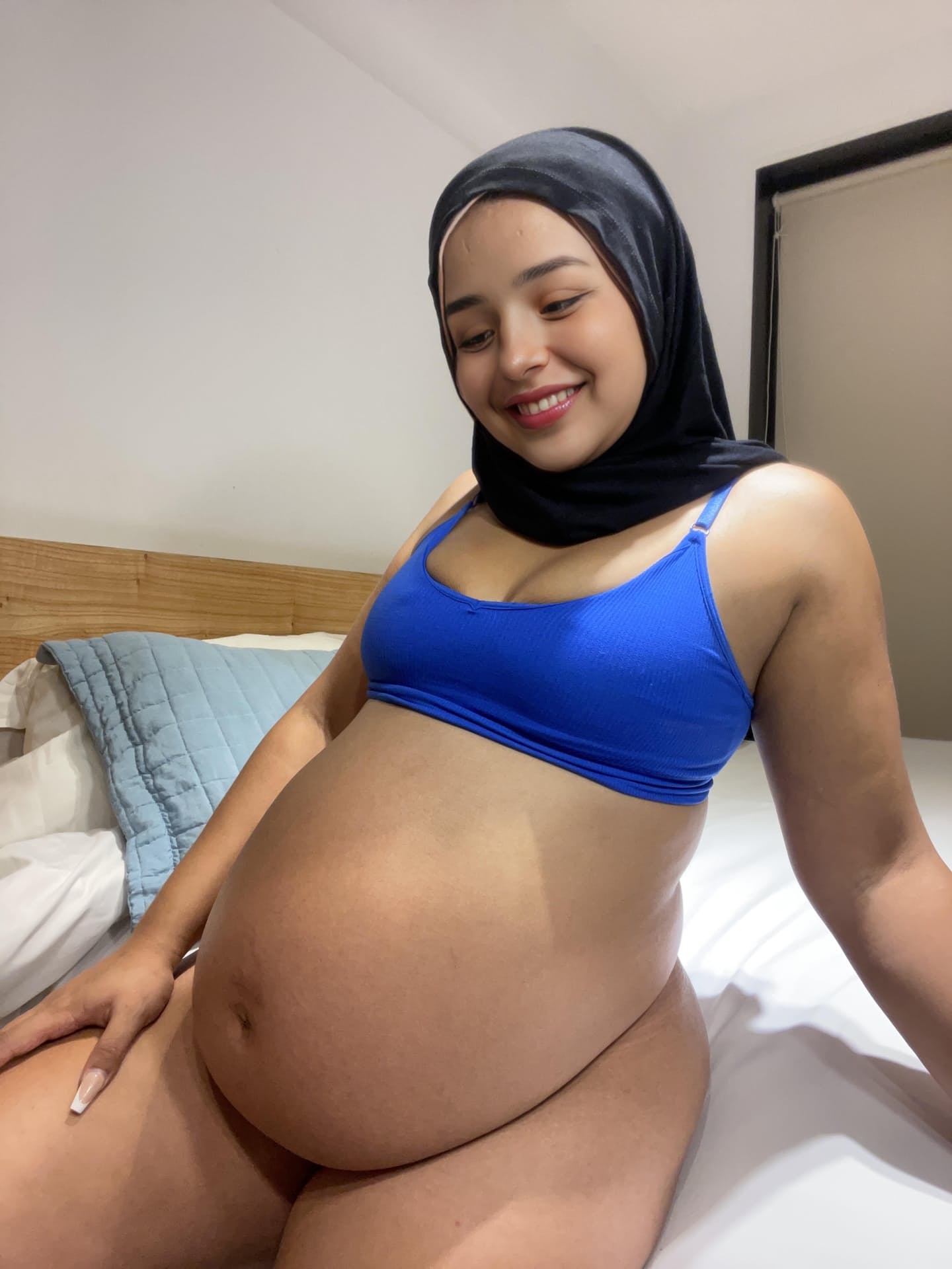 Ein Model aus dem Nahen Osten zeigt ihren riesigen Bauch, während sie einen schwarzen Niqab trägt