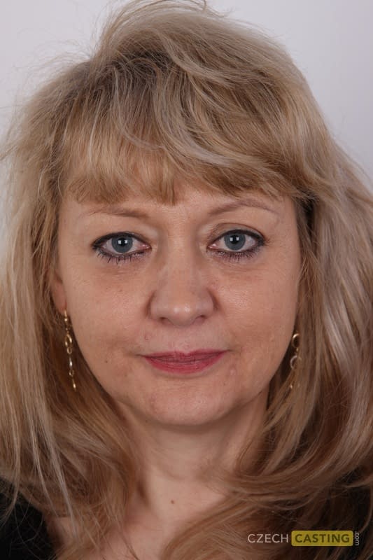 Eine ältere Blondine mit einem kleinen Bauch zieht sich für ihr Nackt-Debüt komplett aus