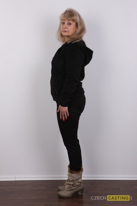 Eine ältere Blondine mit einem kleinen Bauch zieht sich für ihr Nackt-Debüt komplett aus