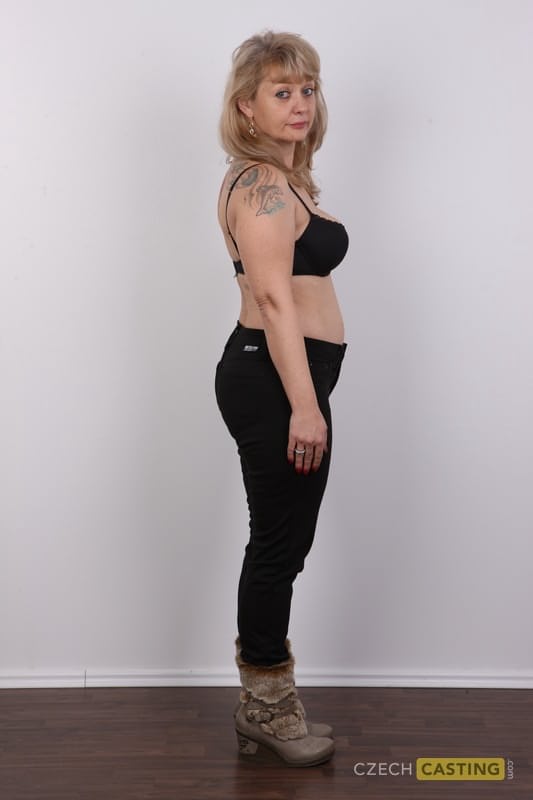 Eine ältere Blondine mit einem kleinen Bauch zieht sich für ihr Nackt-Debüt komplett aus