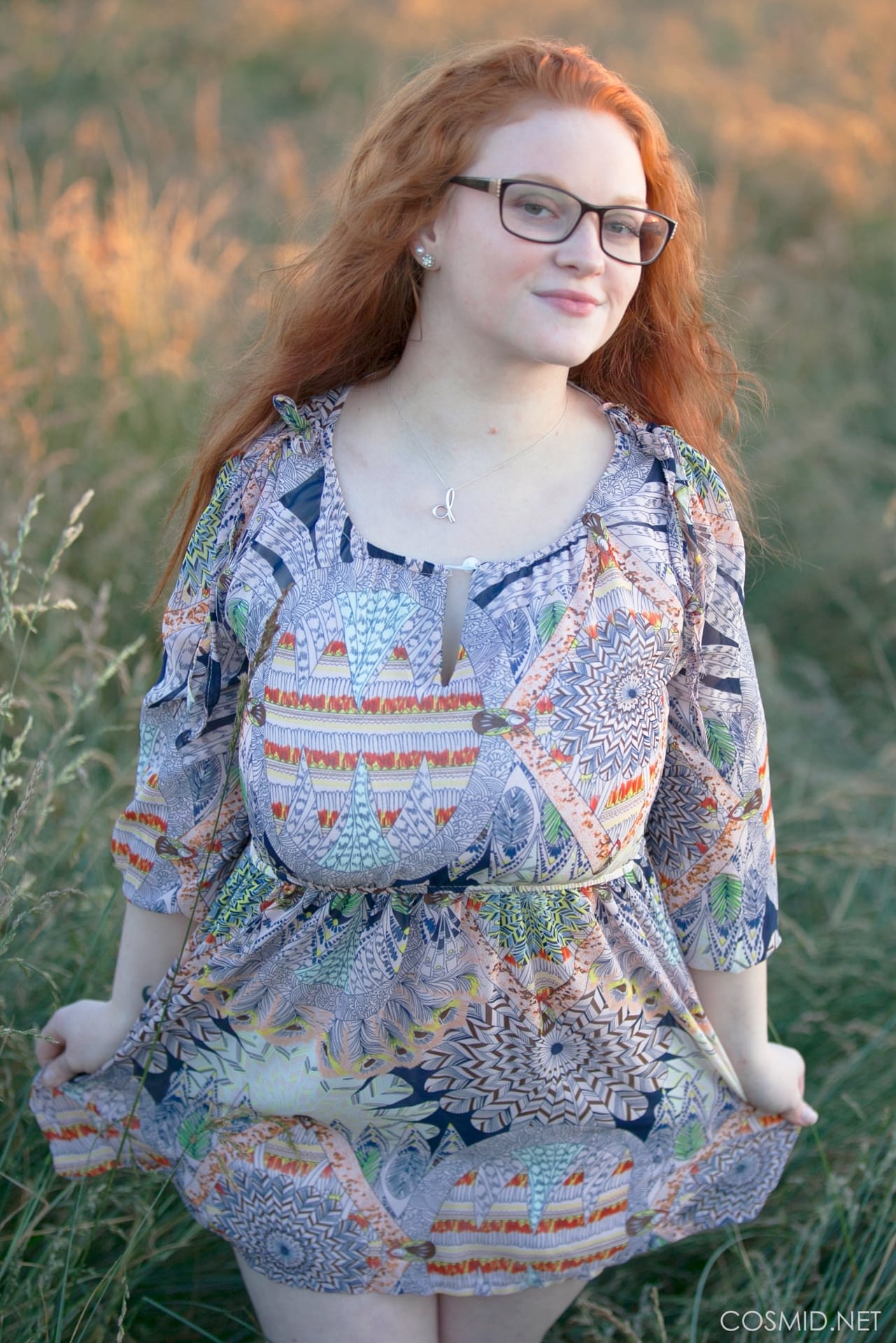 Die heiße rothaarige BBW Kaycee entblößt ihre riesigen Brüste und geht auf einem Feld auf die Knie