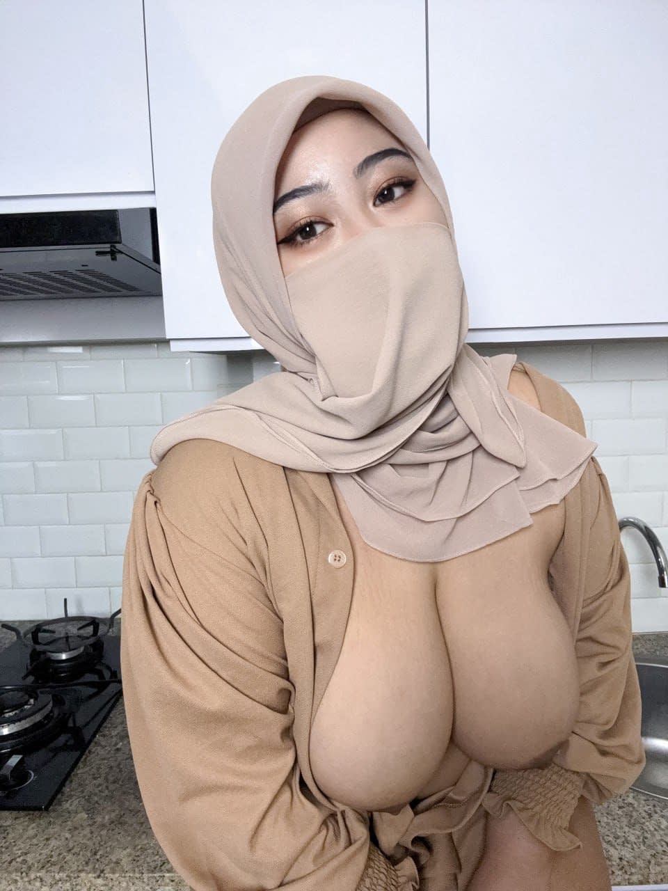 Eine Sexy Milf Mit Riesigen Brüsten Zeigt Ihre Straffen Brüste In Einer Gesichtsmaske Und Einem Hijab
