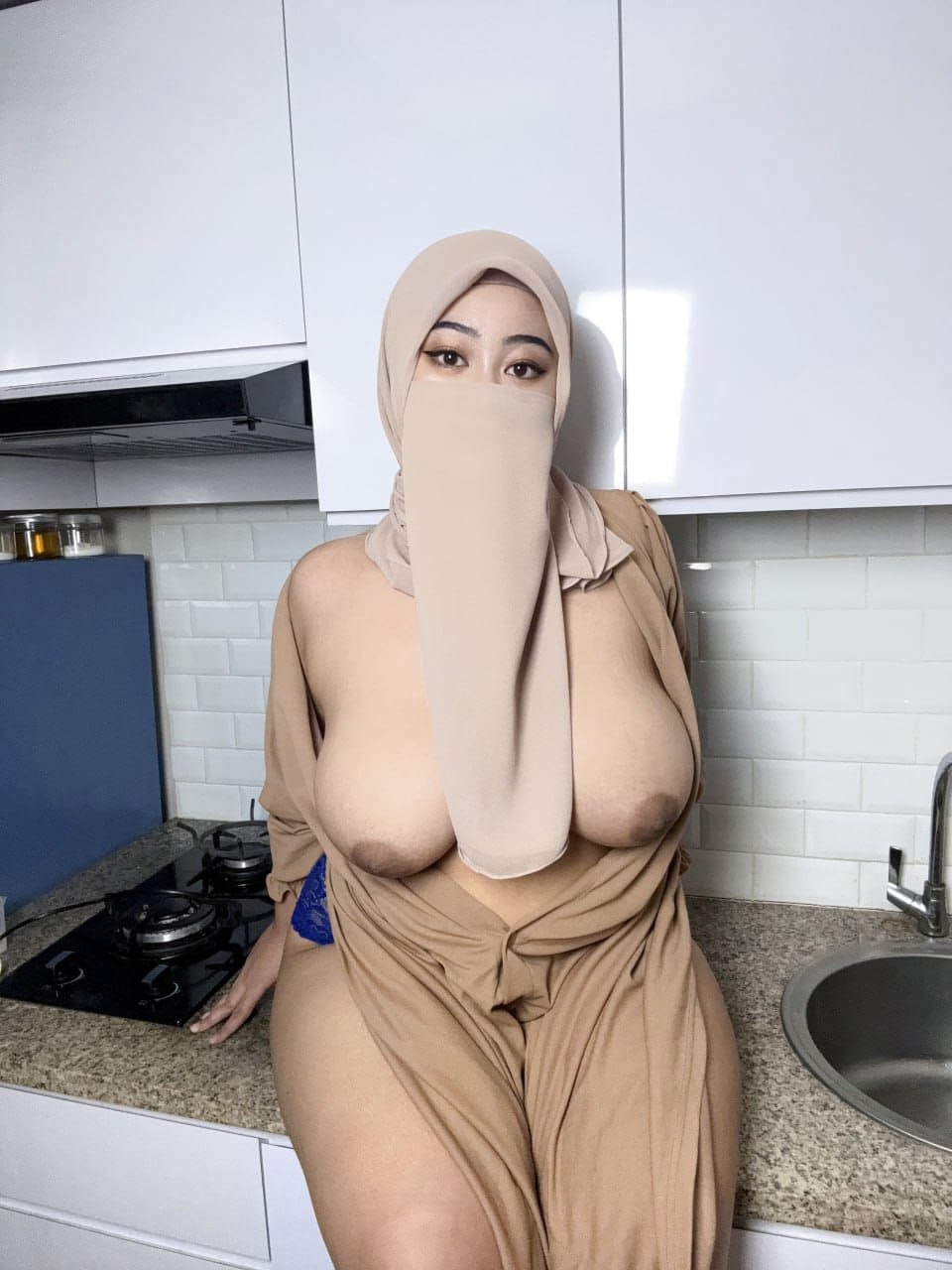 Eine Sexy Milf Mit Riesigen Brüsten Zeigt Ihre Straffen Brüste In Einer Gesichtsmaske Und Einem Hijab