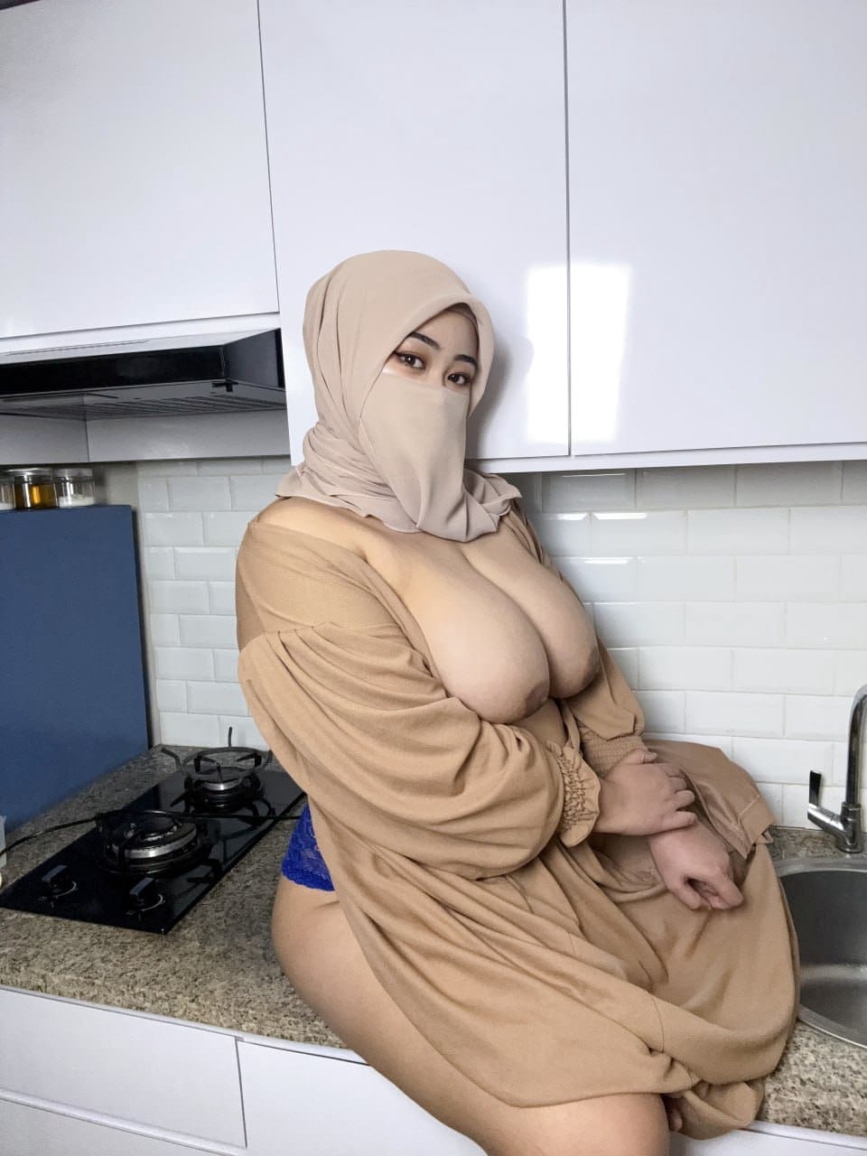 Eine Sexy Milf Mit Riesigen Brüsten Zeigt Ihre Straffen Brüste In Einer Gesichtsmaske Und Einem Hijab