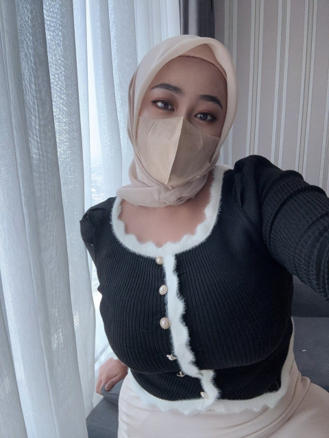 Ein Mädchen Zeigt Allein Ihre Großen Brüste, Während Sie Einen Hidschab Und Eine Gesichtsmaske Trägt