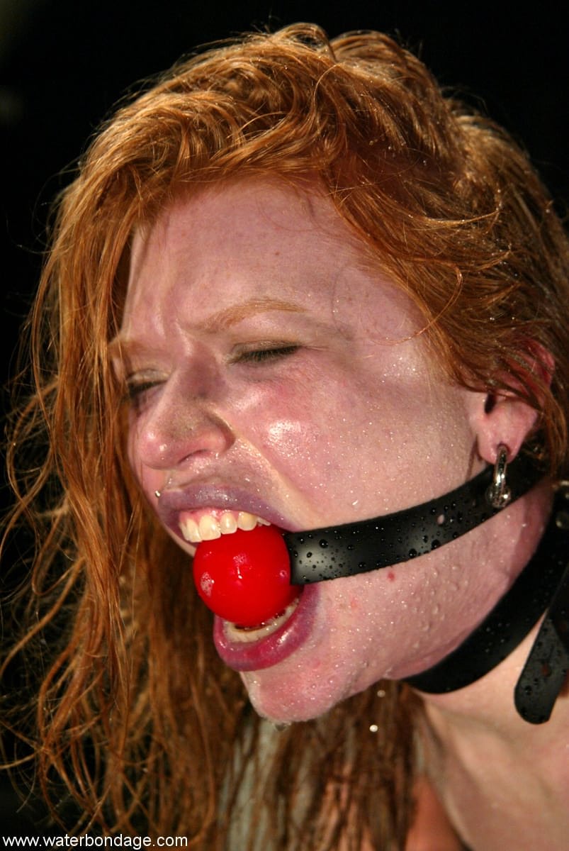 Die Unterwürfige Rothaarige Madison Young Wird Mit Einem Ballknebel Geknebelt Und An Eine Säule Gefesselt