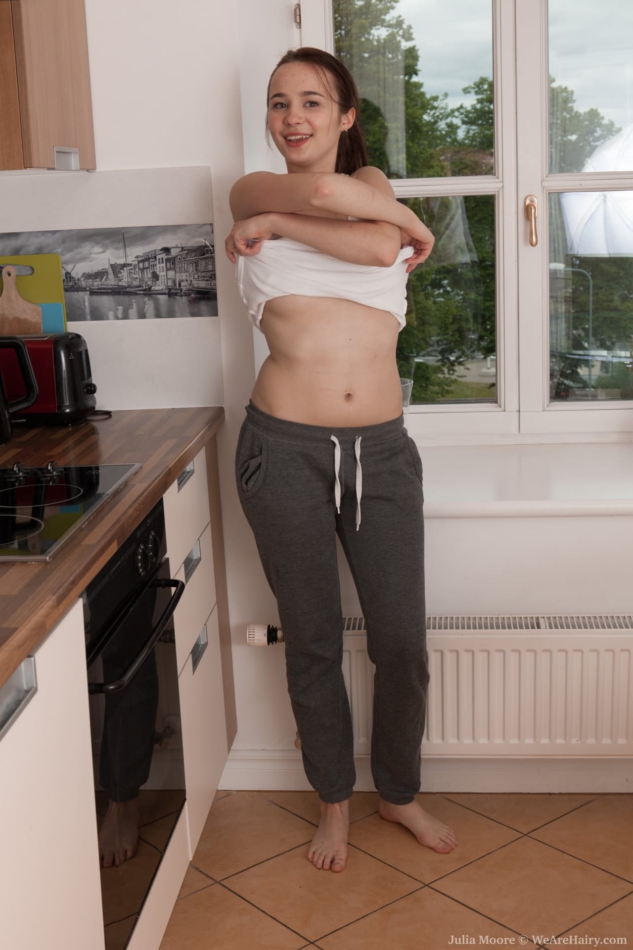 Die Amateurin Julia Moore Spreizt Ihren Schamhaarbüschel, Nachdem Sie Sich In Der Küche Nackt Ausgezogen Hat